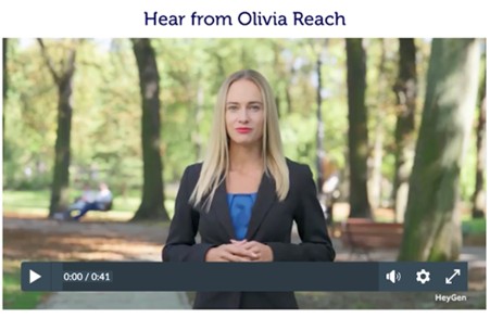 A screenshot of a video playback module embedded on a webpage, the video thumbnail features a blonde Caucasian women (with vivid pink lipstick, wearing a black suit jacket and royal blue blouse underneath) standing in a nature area filled with trees and park benches